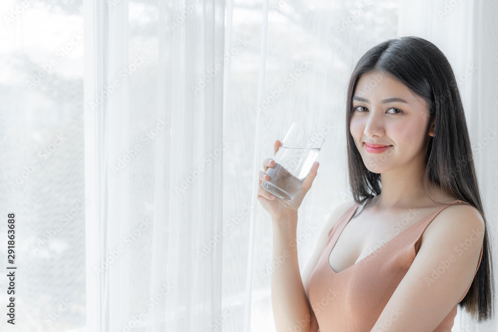 Beautiful beauty woman Asian cute girl feel happy drinking Clean drink water for good health in the morning , enjoying time in her home white bedroom background - lifestyle beauty woman concept Beautiful beauty woman Asian cute girl feel happy drinking Clean drink water for good health in the morning , enjoying time in her home white bedroom background - lifestyle beauty woman concept