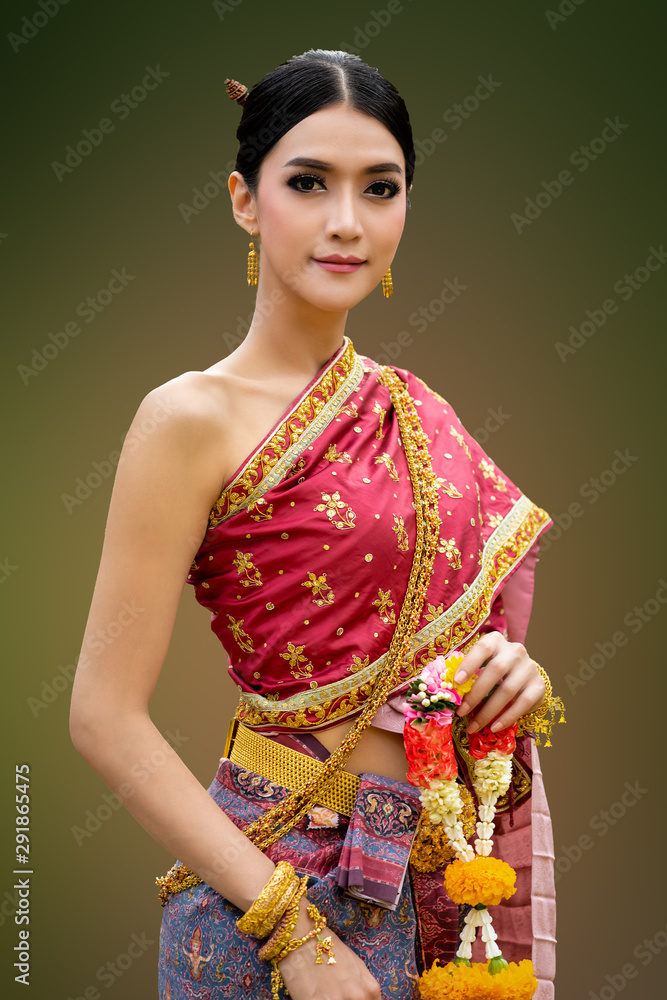 asian women in thai traditional red dress and golden jewellery with flower on hand