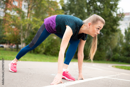 Athletic girl, on a treadmill, getting ready to start.