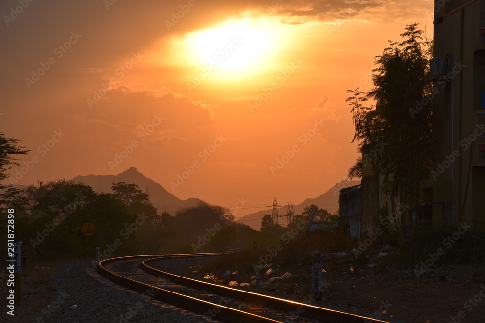 sunset between mountains and railway track