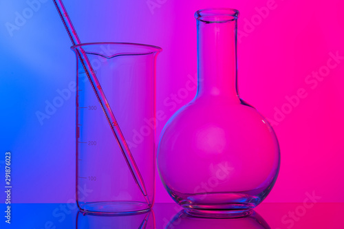 Chemical glassware close up on neon pink-purple background
