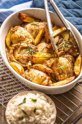 Chicken legs roasted with american potatoes in baking dish