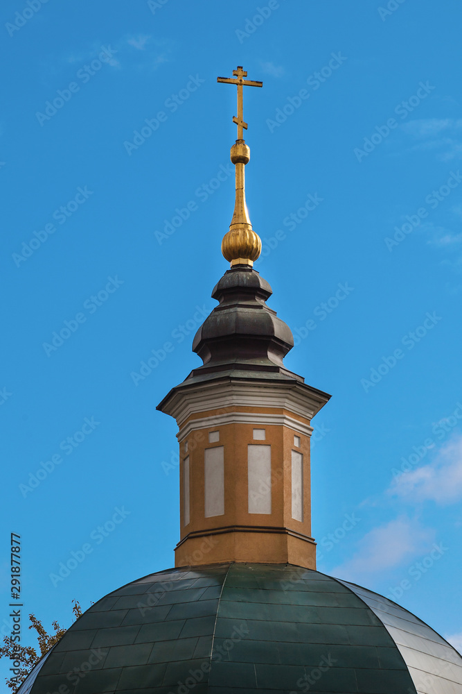 Golden orthodox cross on the dome of the old church