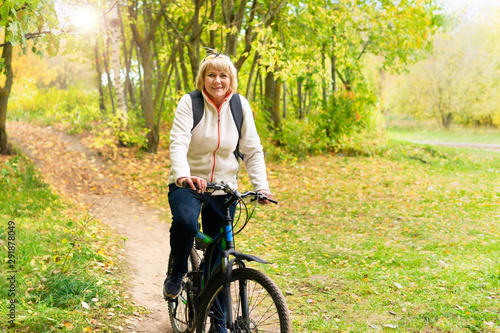 A woman on a Bicycle rides on the road in the Park