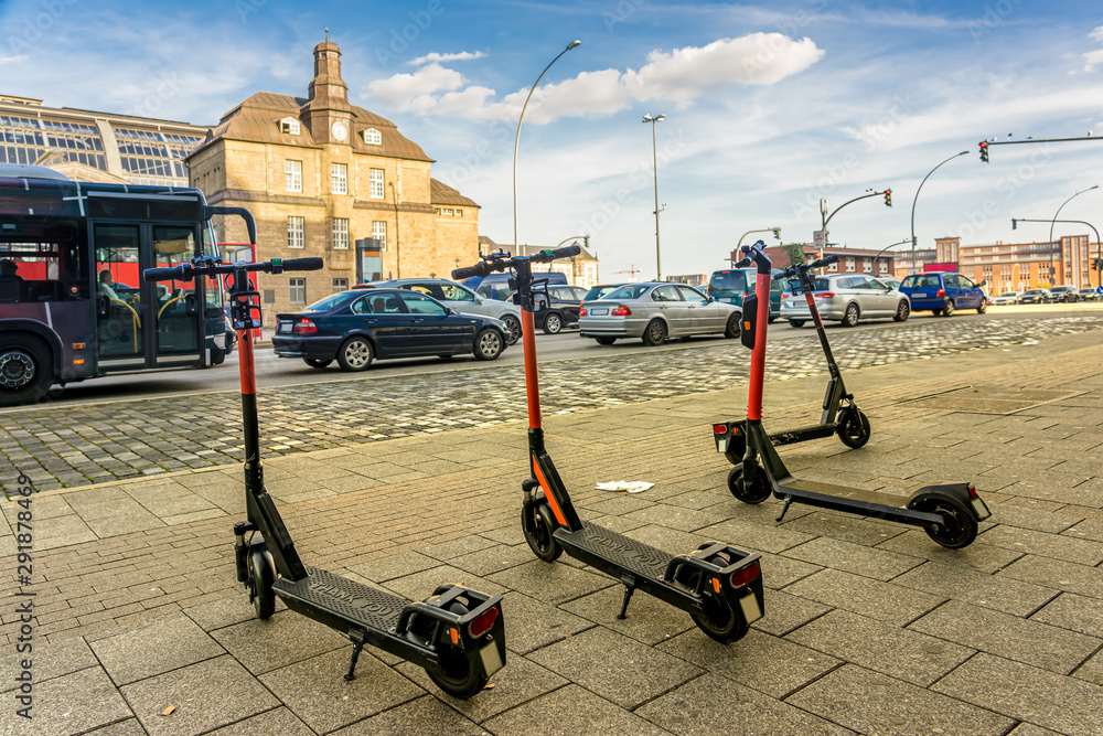 E Scooter vor einer befahrenen Straße mit Autos und Bus StockFoto Adobe Stock E Scooter vor einer befahrenen Straße mit Autos und Bus StockFoto Adobe Stock