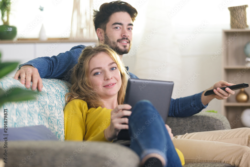 young happy couple with digital tablet on sofa at home young happy couple with digital tablet on sofa at home