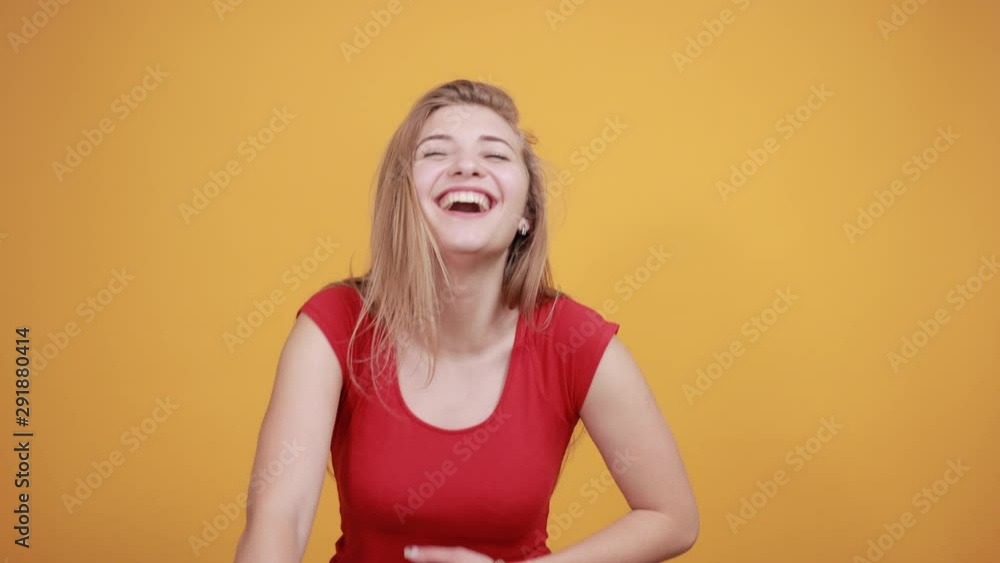 young blonde girl in red t-shirt over isolated orange background shows emotions young blonde girl in red t-shirt over isolated orange background shows emotions