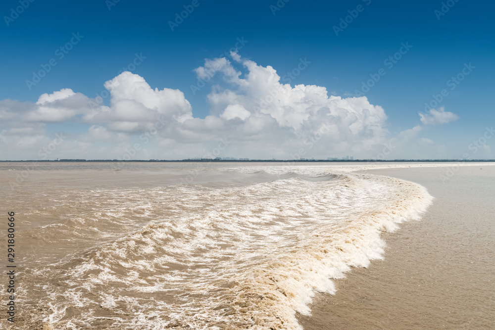 Fototapeta premium qiantang river tide against a blue sky