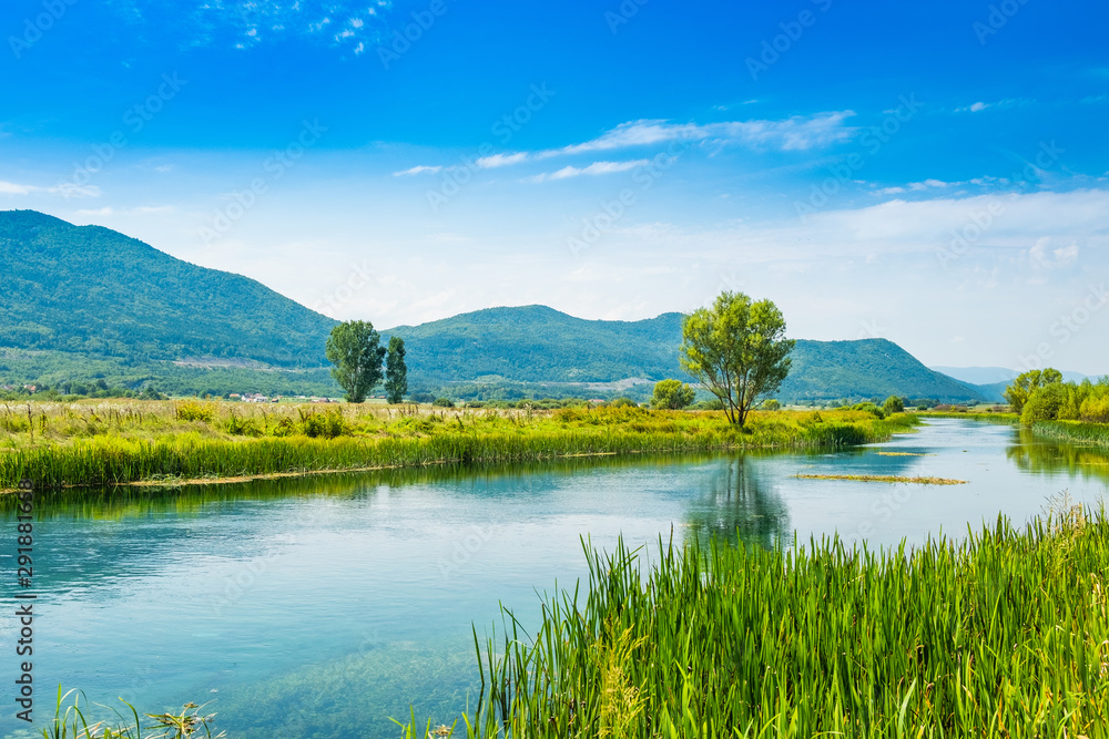 Beautiful nature landscape, Gacka river among grass banks, Lika region of Croatia
