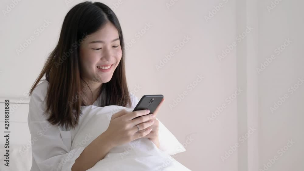 Asian woman typing app social media in the smartphone at bed room. Concept of technology, communication and shopping. Asian woman typing app social media in the smartphone at bed room. Concept of technology, communication and shopping.