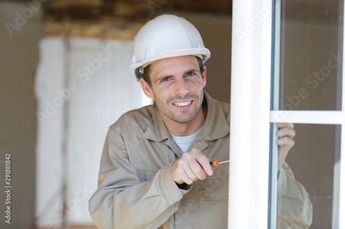 portrait of glazier using screwdriver on pvc windows