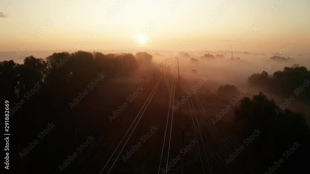 Railway track at sunrise in the fog. View from the drone Railway track at sunrise in the fog. View from the drone