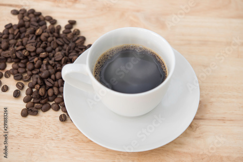 Hot black coffee and smoke on white cup with coffee beans