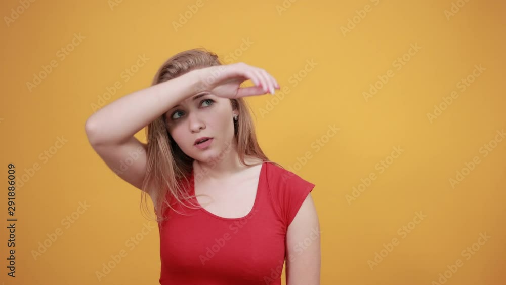 young blonde girl in red t-shirt over isolated orange background shows emotions young blonde girl in red t-shirt over isolated orange background shows emotions