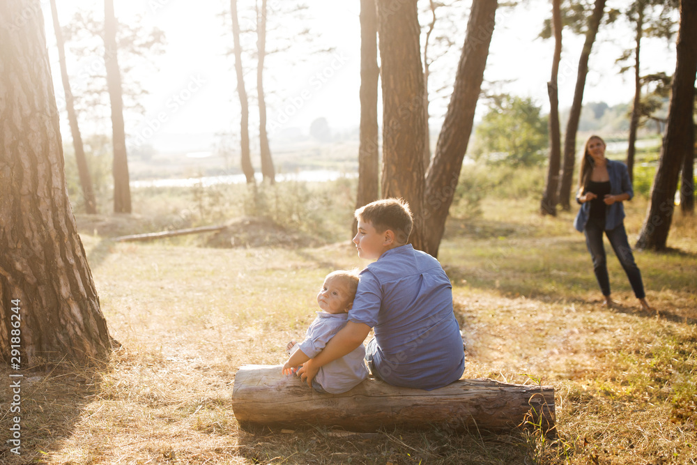 A mom with two sons is spending time outdoors. Happy family A mom with two sons is spending time outdoors. Happy family