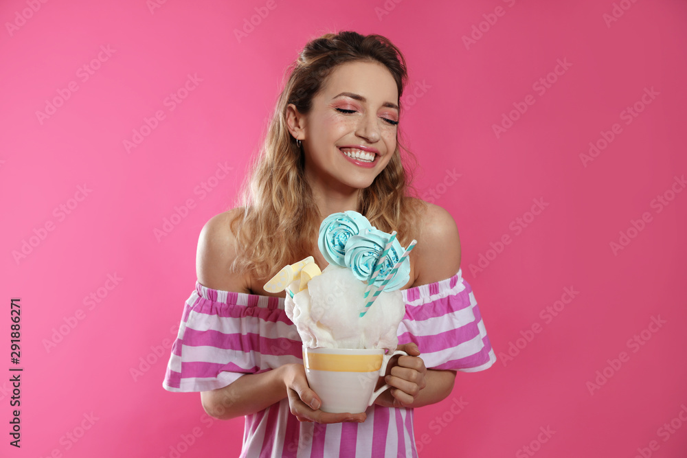 Portrait of young woman holding cotton candy dessert on color background Portrait of young woman holding cotton candy dessert on color background