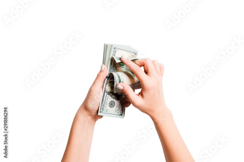 Top view of a bundle of money in female hands. Image of counting dollars on white isolated background. Tax concept