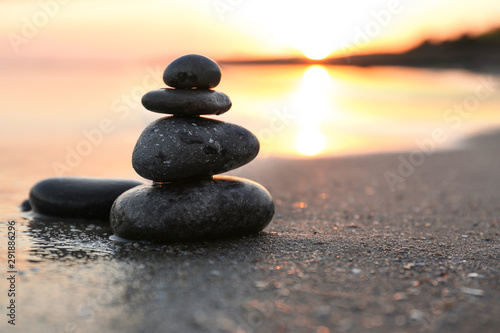 Photo Dark stones on sand near sea at sunset, space for text