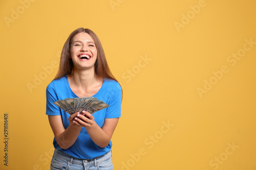 Portrait of happy lottery winner with money on yellow background, space for text