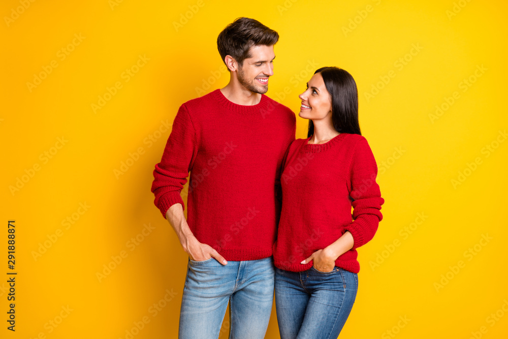Portrait of charming spouses hug smile enjoy wear red jumper denim jeans stand isolated over yellow background Portrait of charming spouses hug smile enjoy wear red jumper denim jeans stand isolated over yellow background