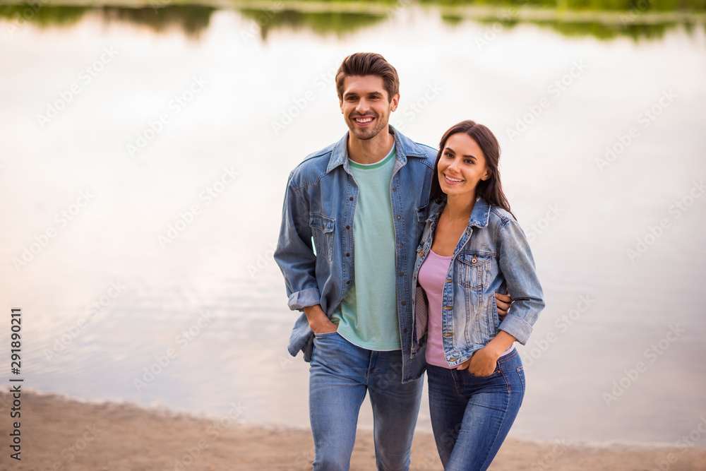 Portrait of charming married couple hug moving wearing denim jeans jackets blazers outdoors in park Portrait of charming married couple hug moving wearing denim jeans jackets blazers outdoors in park