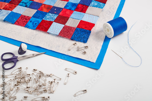 Foto Assembling of a quilt sandwich, curved basting pins and sewing accessories