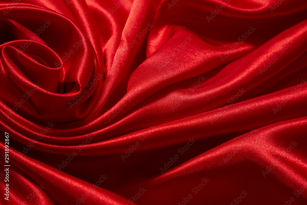 Obraz premium Luxury red satin smooth fabric background for celebration, ceremony, event invitation card or advertising poster