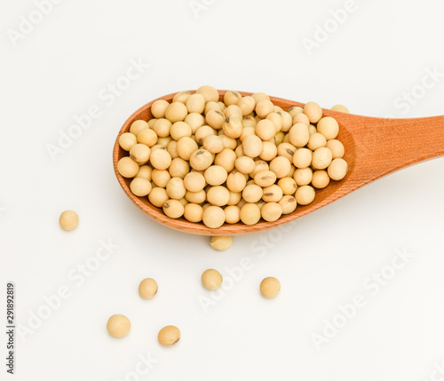 soy beans in wooden spoon on white background
