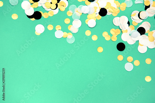 Gold, silver, black and white foil confetti sparse on trendy mint colored background. Simple holiday concept. Design template. Corner frame with copy space for text. Top view, flat lay