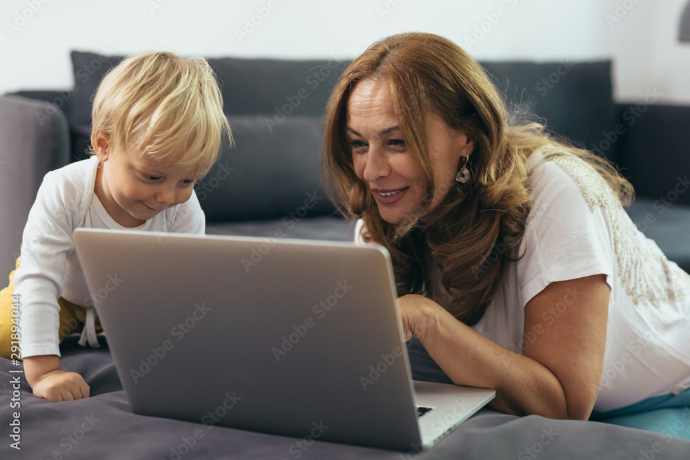 woman with her grandson using laptop computer at home woman with her grandson using laptop computer at home
