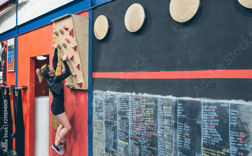 Sportswoman training hanging on the climbing wall at the gym photo