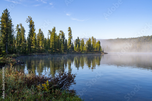 Beautiful mountain lake with pine trees and green grass , Ergaki national park, Siberia, Russia