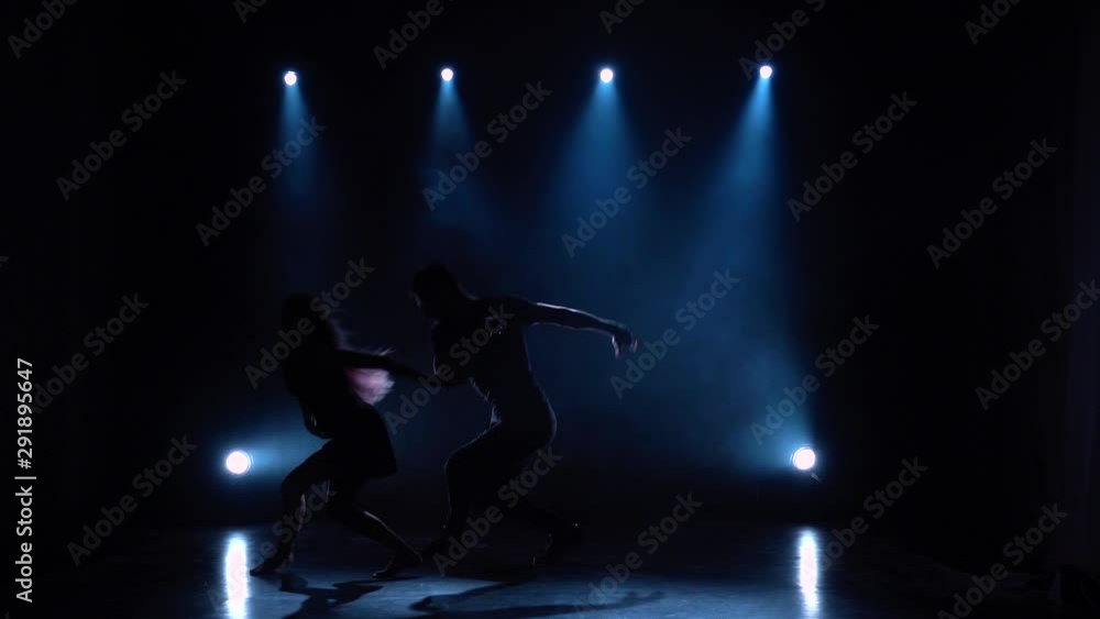 Dances contemp performed by two ballroom dancers, slow motion. Silhouette