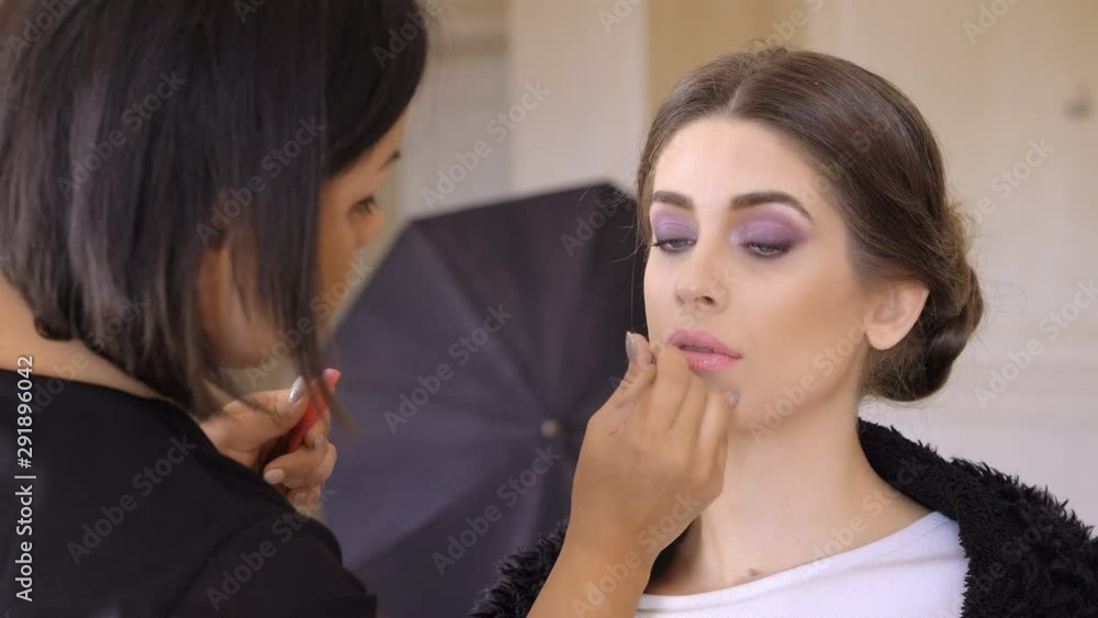 Makeup Artist Applying Lip Gloss On Lips beautiful Model Makeup Artist Applying Lip Gloss On Lips beautiful Model