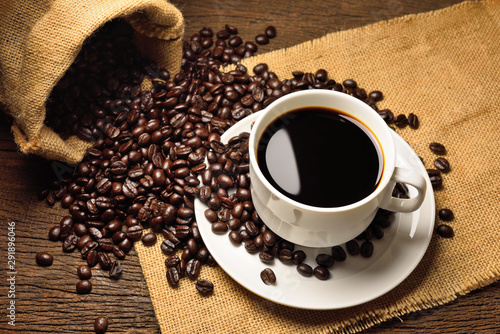 cup of coffee and beans on wooden background