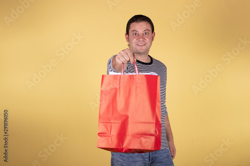 Hombre haciendo compras fondo amarillo 