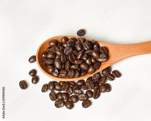 Coffee bean in wooden scoop on white background.