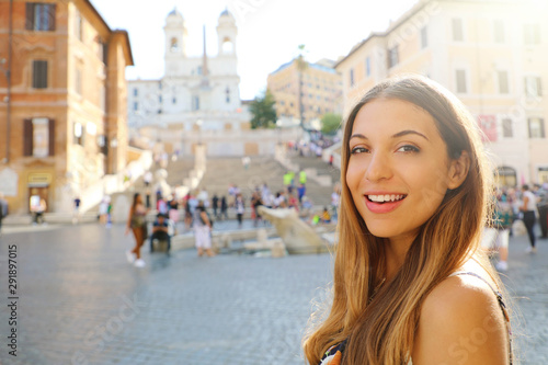 Close up of beautiful fashion woman in Piazza di Spagna square in Rome with Spanish Steps and Barcaccia fountain on the background.