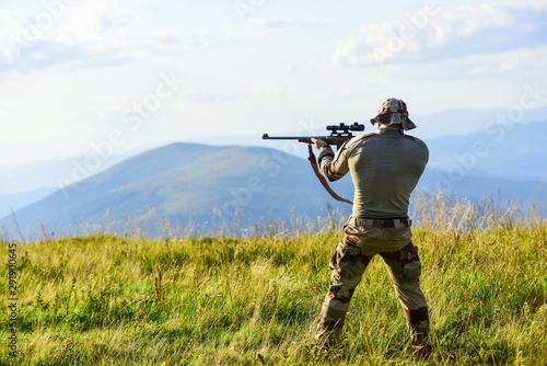 Nice shot. Rifle for hunting. Hunter hold rifle. Hunter mountains landscape background. Focus and concentration experienced hunter. Army forces. Man military clothes with weapon. Brutal warrior