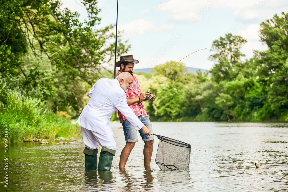 Friends fishing. Perfect weekend. Successful catch. Elegant bearded man and brutal hipster fishing. Hobby and recreation. Relax in natural environment. Summer vacation. Family day. Fishing team Friends fishing. Perfect weekend. Successful catch. Elegant bearded man and brutal hipster fishing. Hobby and recreation. Relax in natural environment. Summer vacation. Family day. Fishing team