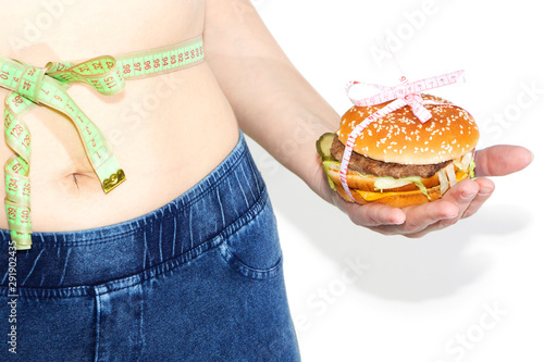 Burger cheeseburger in hands with measure tape isolated on white background. Healthy weight loss diet concept