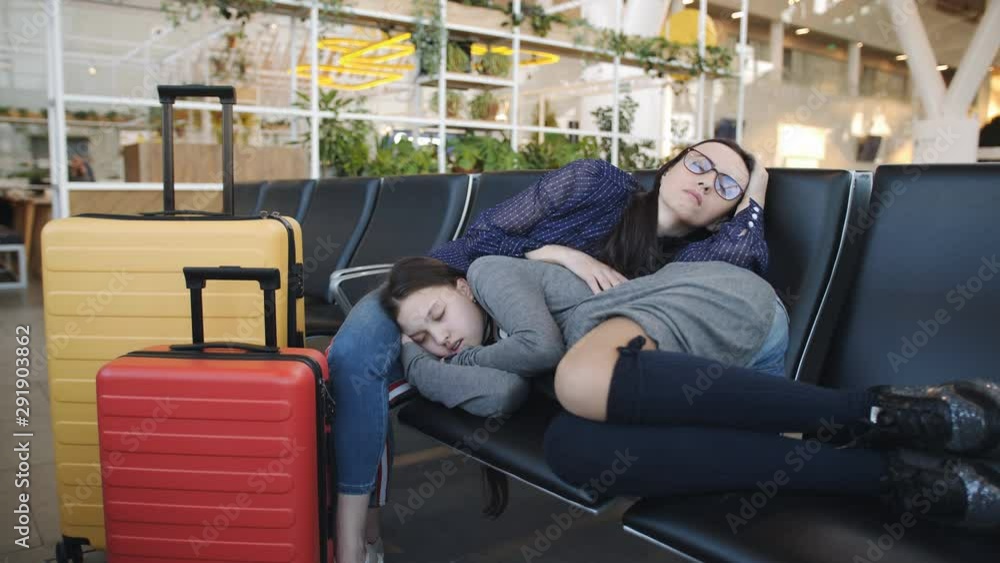 Woman with daughter teen together sleeping on chairs in the airport waiting for departure. Woman with daughter teen together sleeping on chairs in the airport waiting for departure.