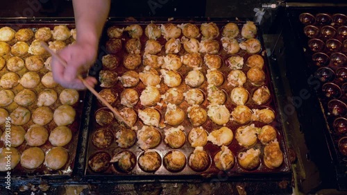 Cooking Takoyaki on hot pan Famous food Osaka Japan street food 4K Footage photo