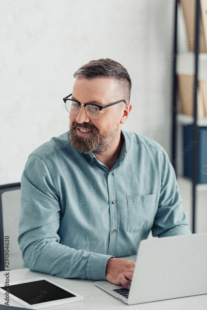 handsome businessman in shirt and glasses using laptop in office handsome businessman in shirt and glasses using laptop in office