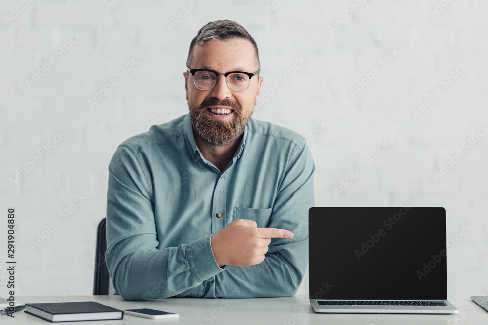 handsome businessman in shirt pointing with finger at laptop with copy space website handsome businessman in shirt pointing with finger at laptop with copy space website