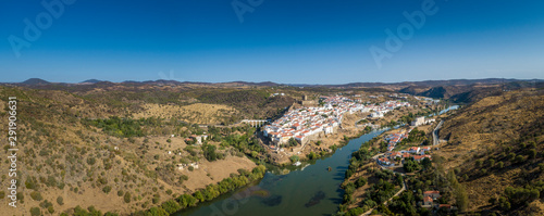 Fototapeta Naklejka Na Ścianę i Meble -  Aerial view of the town of Mértola in southeastern Portuguese Alentejo destination region, located in the margin of Guadiana River, whit its medieval castle, located on the highest point. Portugal.