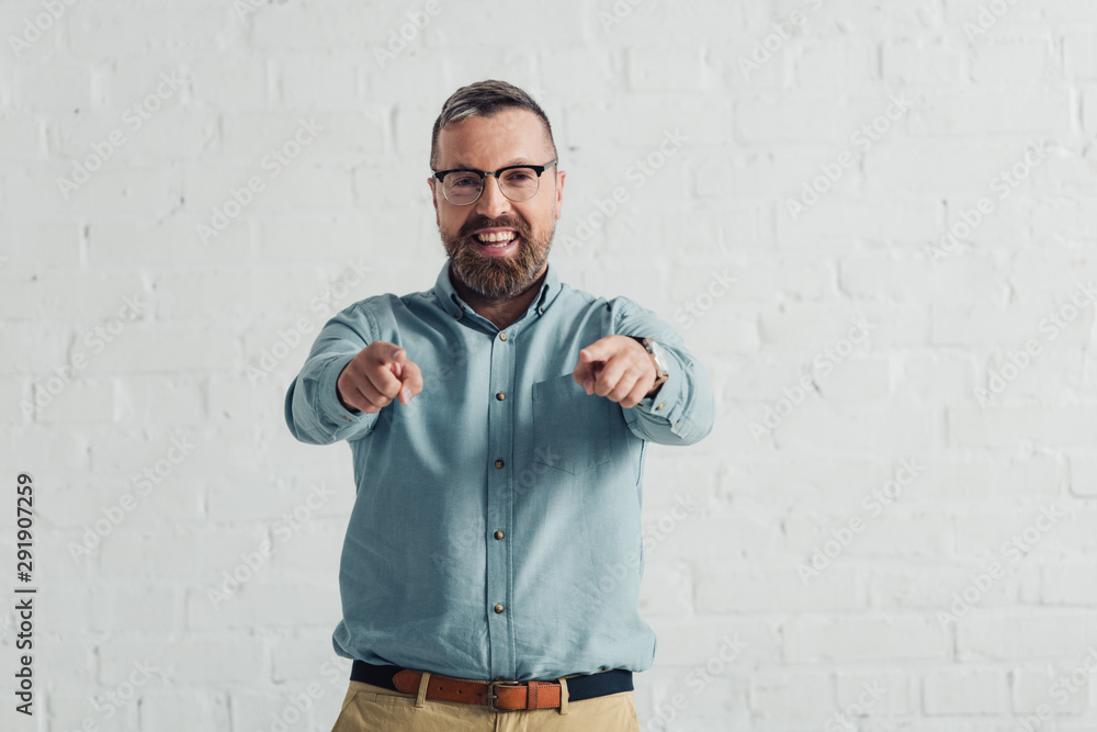 handsome and smiling businessman in shirt pointing with finger handsome and smiling businessman in shirt pointing with finger
