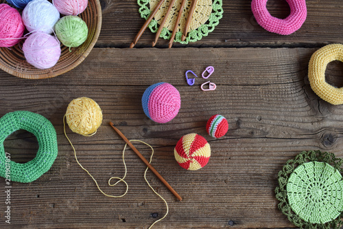 Making colored crochet balls. Toy for babies and toddlers to learn mechanical skills and colors. On the table threads, needles, hook, cotton yarn. Handmade crafts. DIY concept.