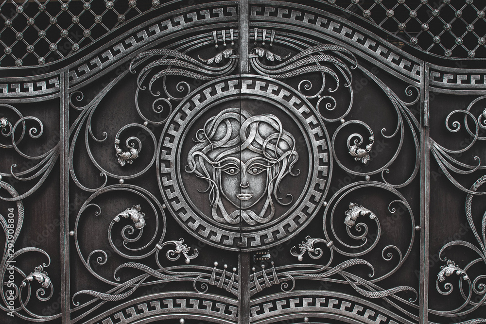 Vintage wrought iron gate with a female face