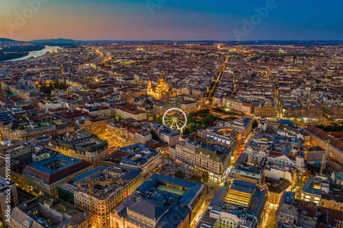 Budapest, Hungary - Aerial skyline view of city centre of Budapest with Elisabeth Square, ferris wheel and St. Stephen's Basilica with clear blue and orange sky © zgphotography